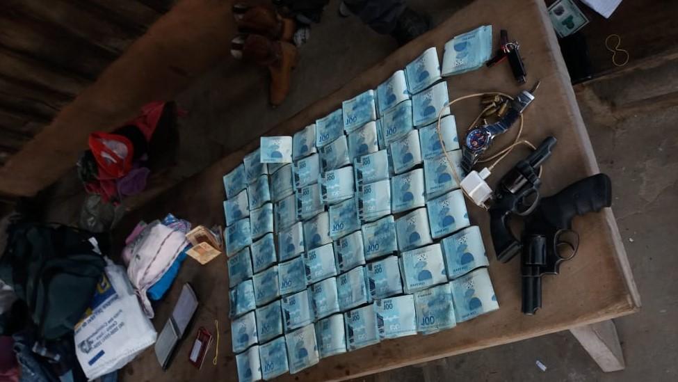 Dinheiro e armas que foram apreendidos pelos policiais. (Foto: divulga&ccedil;&atilde;o PM/MT)