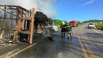 Motorista morre após carreta carregada com bebida tombar e pegar fogo