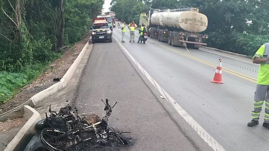 Motociclista morre após bater de frente com carreta e veículo pegar fogo 