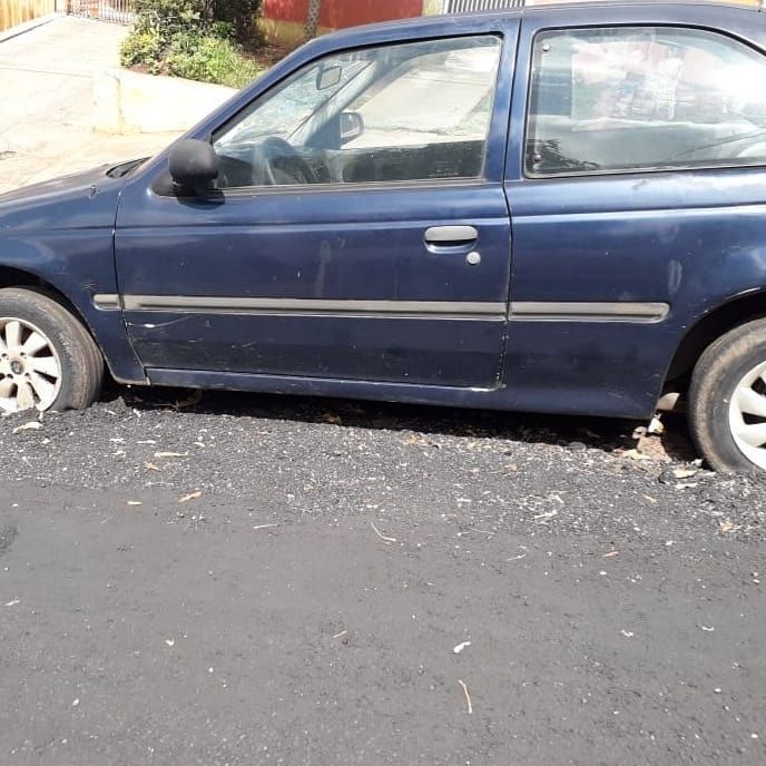 Prefeitura faz asfalto pela metade em rua por conta de carro abandonado