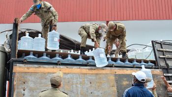 Bombeiros Militares descarregando galões de 20 litros de álcool. (Foto: Tchelo Fiigueiredo/Secom-MT)