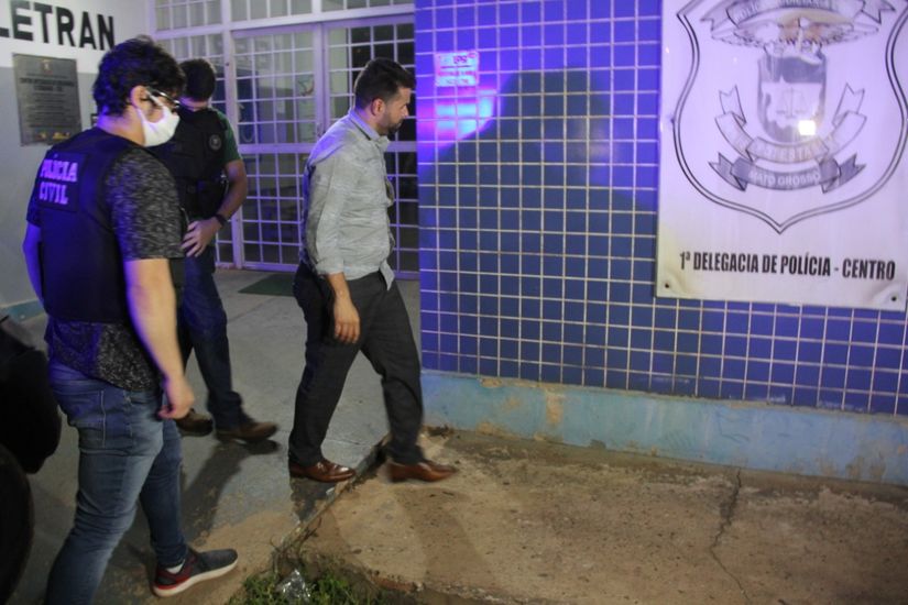 Suspeito chegando na 1ª Delegacia de Polícia. (Foto: GazetaMT)