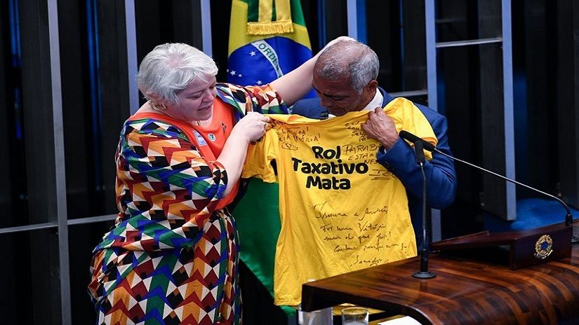 Romário recebe camiseta de Isaura Sarto, advogada e ativista da inclusão, em comemoração à aprovação do PL
